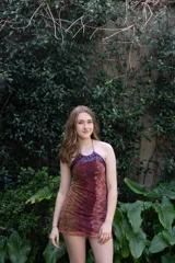 Vestido corto turquesa con escote halter y espalda descubierta. El cuello es alto y las tiras se atan en la nuca.