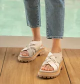 Sandalias de cuero vacuno color marrón, con tiras anchas cruzadas en el empeine, elástico en el talón y doble suela de goma deportiva.