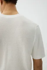 Remera blanca de algodón con tejido de punto calado, cuello redondo y corte estándar.