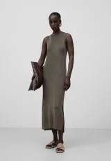 Vestido largo de punto metalizado con cuello redondo y sisas amplias. Diseño con abertura lateral.