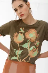 Remera lila de algodón con estampado de flores en tonos naranja y rosa.