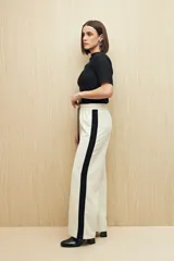 Pantalón de jogging color crema con cintura elástica, cordón ajustable y franja lateral negra.
