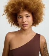 Body básico color durazno, con escote asimétrico y un solo hombro. Confeccionado en microfibra de poliamida y elastano.