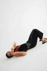 Chaleco calado negro con diseño de rayas diagonales rojas, beige y blancas.