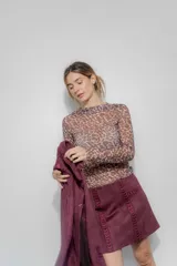 Minifalda color borgoña confeccionada en gamuza sintética con bordado de flechas en la parte delantera.