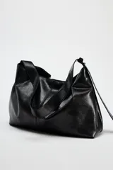 Bolso shopper marrón de efecto acharolado con asa de hombro ajustable, bolsillo interior con cremallera y cierre magnético.