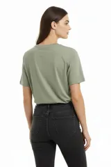 Remera verde militar de algodón con cuello redondo, manga corta y bolsillo de encaje en el pecho.