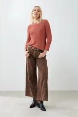 Sweater tejido color ladrillo, con cuello redondo y ruedo curvo.
