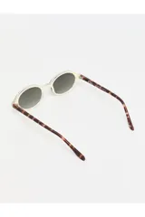 Lentes de sol Tiwi modelo Bell, con montura beige brillante y lentes verdes degradados.