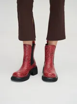 Botas negras de cuero con diseño floral en relieve, corte Chelsea, elásticos laterales, plataforma delantera de 2cm y tacón de 5,5 cm.