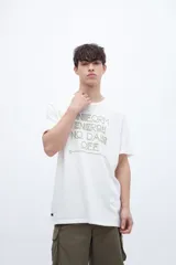 Remera color crudo con estampa frontal con texto en color ocre.