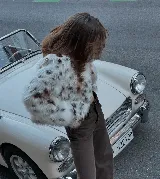 Campera corta de piel sintética con estampado animal print en tonos blanco, marrón y negro.