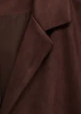Chaqueta marrón con efecto piel, cuello con solapa, sin cierre y detalle de flecos en mangas y espalda.
