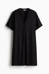 Vestido túnica negro a la rodilla en tejido liviano de viscosa con cuello mao y abertura en V. Modelo de corte holgado con hombros levemente caídos, mangas cortas y bajo recto con tajos laterales.