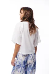Blusa blanca de algodón con escote en V y mangas cortas amplias.