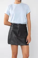 Falda mini de cuero color negro con costuras en color camel.