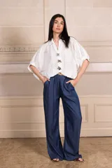 Camisa blanca calada con botones y mangas cortas. Incluye tres prendedores con forma de flor.