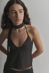 Top halter negro con lunares blancos, de tela tipo gasa, con espalda descubierta y lazos para atar al cuello y la espalda.