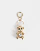Llavero dorado con dije de oso de peluche con un cristal en forma de corazón en el pecho.