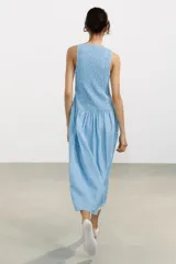Vestido midi con estampado de cuadros vichy celestes y blancos, cuello redondo y sisa.