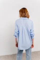 Camisa celeste de algodón, corte clásico, manga larga y cuello camisero.