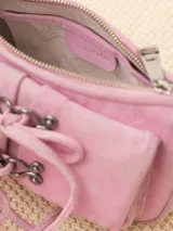 Mini cartera tipo baguette color rosa, realizada en cuero ovino. Tiene acceso mediante un cierre metálico, interior forrado en tejido jacquard con bolsillo y bolsillos frontales con apliques metálicos níquel.