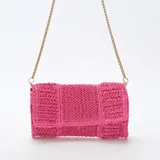 Bolso de mano tipo clutch color fucsia, tejido en rafia, con solapa y cadena dorada para usar como bandolera.