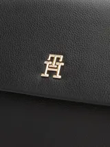 Mochila Tommy Hilfiger de poliuretano negro con acabado liso, cierre de solapa magnético, asa superior, dos correas ajustables, un compartimento principal y un bolsillo interior con cremallera.