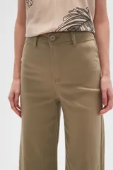 Pantalón de jean color beige, de corte flare y tiro alto, con terminación desflecada.