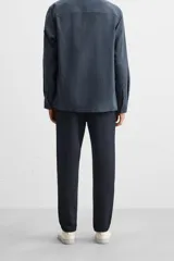 Pantalón negro de corte cropped, con cintura elástica ajustable con cordón, bolsillos laterales y traseros de vivo. El bajo tiene terminación con vuelta.
