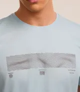 Remera deportiva celeste de poliéster con tecnología Dry, cuello redondo y mangas cortas. Estampa geométrica horizontal en el pecho y recortes en las mangas.