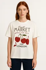 Remera color crudo con estampado de cerezas y texto "Fruit Market Berries for Sale 1999 London".