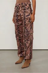 Pantalón cargo de tiro bajo con estampado de piel de serpiente en tonos marrones y negros. Cuenta con puños ajustables y múltiples bolsillos.