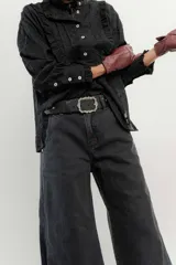 Pantalón de jean azul de pierna ancha y tiro medio, con cinco bolsillos y pespuntes a contratono.