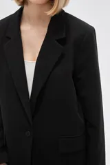 Blazer blanco de viscosa, con cuello solapa, bolsillos frontales y cierre con botón.