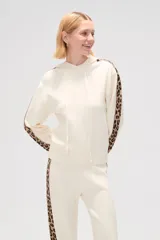 Sweater color crema con capucha y cordones, de tejido de punto, con mangas largas y detalle de franja con estampado animal en mangas y laterales.