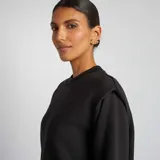 Buzo negro de algodón con cuello redondo y hombreras.
