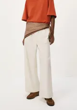 Pantalón de lino color crema, de corte recto y tiro alto, con cintura elástica ajustable con cordón y bolsillos laterales.