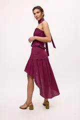 Falda midi color borgoña con tablas hechas con cortes diagonales y frunces.