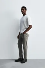Pantalón de jean negro, corte slim fit, con tiro medio, cinco bolsillos, efecto lavado y cierre frontal con cremallera y botón.