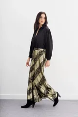 Pantalón amplio de viscosa jacquard con lurex, estampado con manchas de leopardo en negro y dorado. Tiene caída fluida, cintura con elástico trasero y forrería a tono.