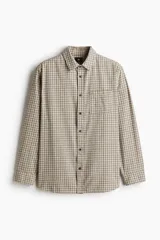 Camisa de franela suave de algodón a cuadros en tonos beige, marrón y rojo, con cuello inglés, tapeta clásica, canesú en la espalda, bolsillo superior abierto, mangas largas con tapeta de manga y puños abotonados, y bajo levemente redondeado.