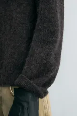 Sweater tipo polo color gris oscuro, de punto con textura, corte regular fit, cuello solapa con abertura frontal, manga larga y terminaciones en rib.