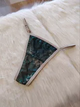 Microtanga de encaje verde con tiras finas color beige.