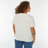 Remera blanca de corte recto, manga corta y cuello redondo. Presenta un bordado calado con motivos florales en el ruedo.