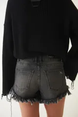 Short de jean negro con tiro bajo, efecto desgastado y flecos en el ruedo.