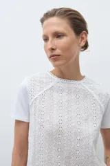 Remera blanca de manga corta con cuello redondo y frente de broderie calado.