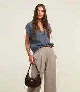 Pantalón wide leg de vestir color beige, con cintura alta, trabillas para cinturón, pliegues frontales y bolsillos laterales.