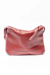 Bolso tipo hobo de cuero sintético color rojo oscuro con textura granulada.