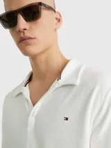Chomba blanca de felpa de Tommy Hilfiger con cuello clásico, corte amplio, logo bordado en el pecho y detalles distintivos de la marca.